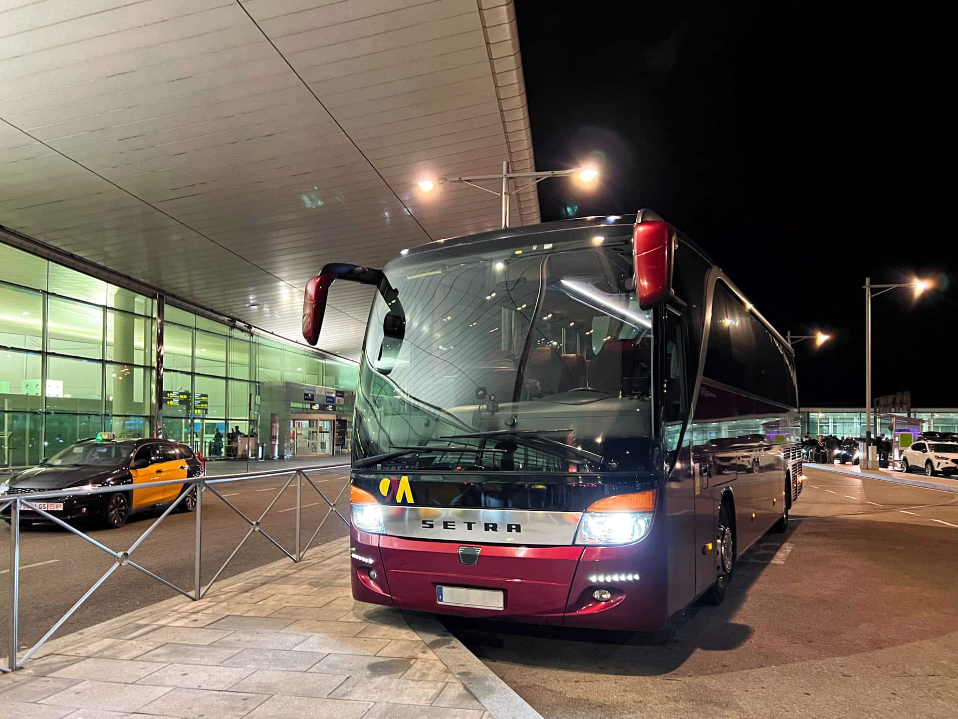 autocar setra descarregant passatgers a l'andana de sortides de l'aeroport el prat -barcelona